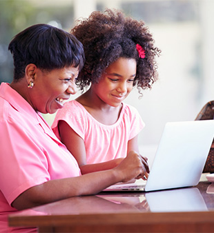 woman and little girl smiling at laptop