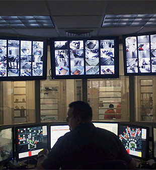 jail staff silhouetted against monitor bank