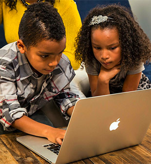 two kids using laptop