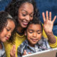 Mother with two kids video visiting over laptop