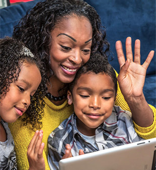 Mother with two kids video visiting over laptop